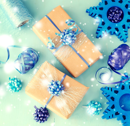 Vintage chrismtas gift boxes on blue background, falling snow effect, decortaion conceptの写真素材