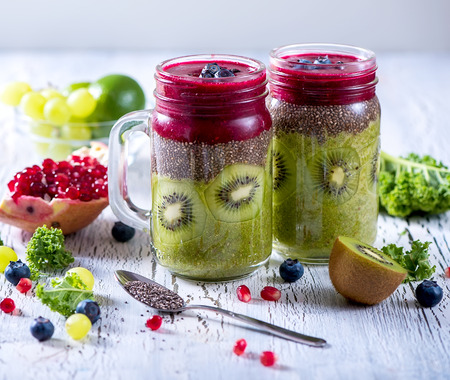 Green and red  smoothie, vitamins diet drink with kale, chia seeds, lime, kiwi, apple, pomegranateの写真素材