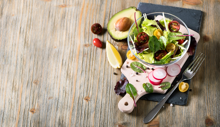 Healthy green salad with avocado, mangold leaves and cherry tomatoes. Vegan snack, vitamins, vegetarian food and diet concept. Copy spaceの写真素材