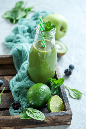 Green smoothie with spinach and lime, healthy juicy vitamin drink diet or vegan food concept, fresh vitaminsの写真素材