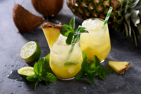 Cold pineapple cocktail with crushed ice, lime, coconut and mint, tropical refreshing lemonade drinkの写真素材