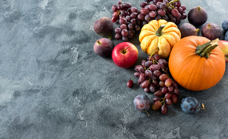 Autumn harvest with pumpkin, grapes, plumps, figs, apples. Healthy organic fruit and vegetables. Thanksgiving, copy spaceの写真素材