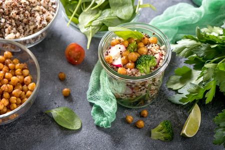 Quinoa salad with baked chickpeas, spinach, avocado and veggies, healthy vegan food, dieting, clean eating, vitamin and protein snackの写真素材