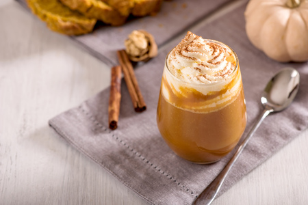Pumpkin spice latte, hot coffee drink with pumpkins, whipped cream and spicesの写真素材