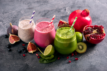 Colorful smoothies with pomegranate, blueberries and spinach, healthy juicy vitamin drink diet or vegan food concept, fresh vitamins, homemade refreshing fruit drinkの写真素材