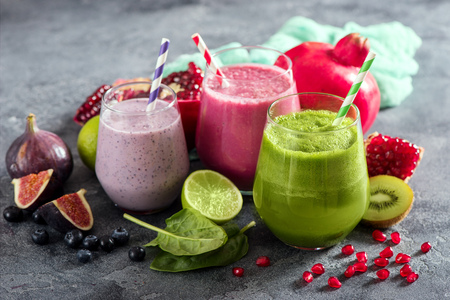 Colorful smoothie, healthy detox vitamin diet or vegan food concept, fresh vitamins, breakfast drink with spinach, pomegranate, figs and blueberriesの写真素材