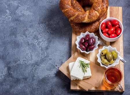 Traditional turkish breakfast with olives, simit bagels, feta cheese, tea, top view, copy space background, oriental foodの写真素材