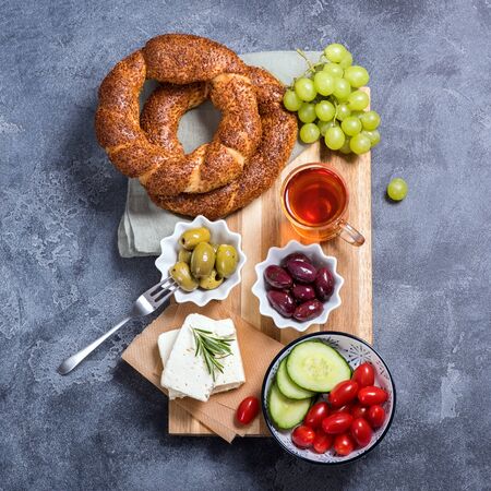 Traditional turkish breakfast with olives, simit bagels, feta cheese, tea, top view, square image, oriental foodの写真素材