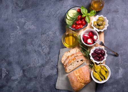 Mediterranean traditional snack with olives, pepperoni, ciabatta, olive oil,  italian or greek food concept, appetizers, antipasti, top view, copy space backgroundの写真素材