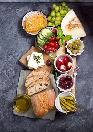 Mediterranean traditional snack with olives, pepperoni, ciabatta, olive oil,  honey, fruits, italian or greek food concept, appetizers, antipasti, top viewの写真素材
