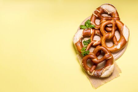 Pretzels on yellow background copy space, german traditional food, european, bavarian snack, oktoberfest conceptの写真素材