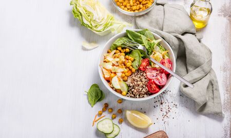 Quinoa salad with baked chickpeas, spinach, tomatoes, healthy vegan food, diet and clean eating concept, cooking at home, dinner and lunch ideas, white copy space background for textの写真素材