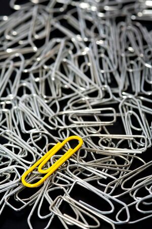 Lots of silver paper clips and one yellow paper clipの写真素材