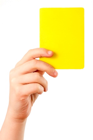 Yellow card in a hand in front of a white backgroundの写真素材