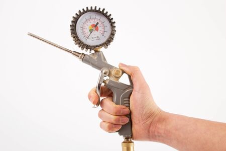 Hand of a woman with a pistol of a compressor in front of a white backgroundの写真素材