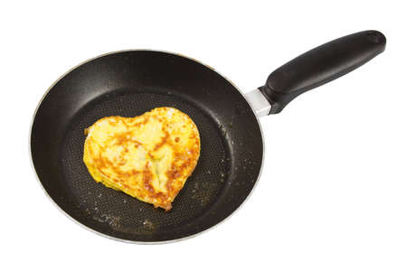 Heart shaped scrambled eggs in a pan over a white backgroundの写真素材