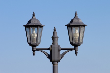Two dark lanterns in front of a blue sky