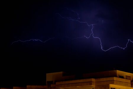 Lightnings in the night above a building