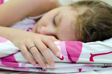Little girl is sleeping in her bedの写真素材