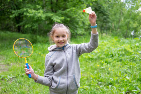 Little girl playing badminton on the street