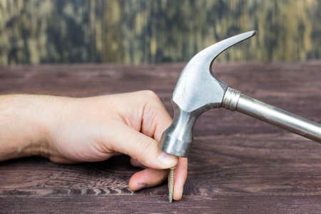 The hammer hits the finger. Board. Nails.の写真素材