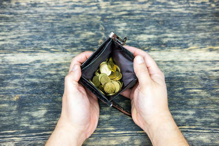 Hands holding an empty wallet with coins.の写真素材