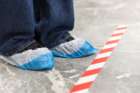 Legs in polyethylene shoe covers in a medical center.の写真素材