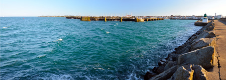 Panorama of the harbor entrance in Joinville in Yeu Island with yacht harbor and town harbor at background and waters of open Atlantic Ocean at foreground. France Vendee Pay loireの写真素材