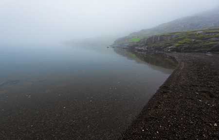 Misty landscape of the gravel beach of Sorvagsvatn Lake in  Faroese island of Vagarの写真素材
