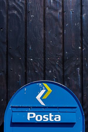 Kirkjubour, Faroe - July 11, 2018 The post box of Faroese postal service is set at the black pained wooden wall.のeditorial素材