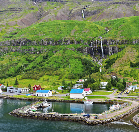 Seythisfjorthur harbor for local boats in eastern Iceland mountain slope is at backgroundの写真素材