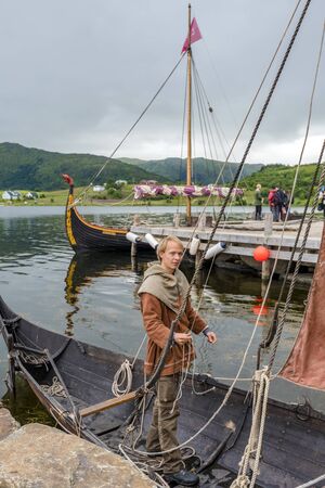 Lofotr, Norway - August 2, 2017  Man preparing Reconstructed Viking boat in the border of Innerpollen salty lake in Vestvagoy island of Lofoten archipelago. The area is a part of Lofotr Historical museum. Nordland, Northern Norway.のeditorial素材