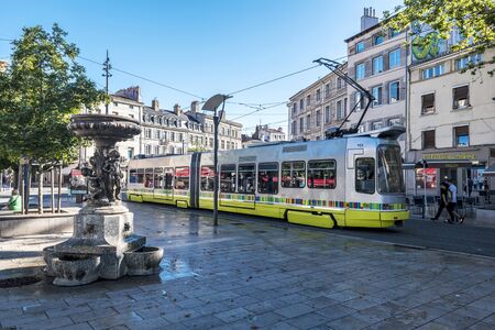 Saint-Etienne, France- July 29, 2019 Street view Saint Etienne downtown. The tramway passing along the Square People's Square. The Statue is at foreground.のeditorial素材