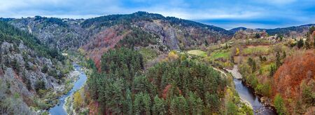 La Loire river flow and the Valley landscape panoramic view with Arlempdes medieval village at right, Paillasses Ravine is at left. Haute-Loire in France, Auvergne-Rhone-Alpes region.の写真素材