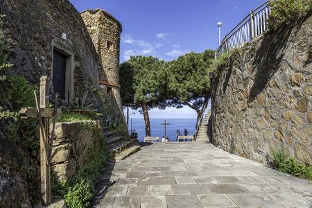 Walk pass to the mirador at Riomaggiore Castle. The wall, entrance and tower of the castle are at...