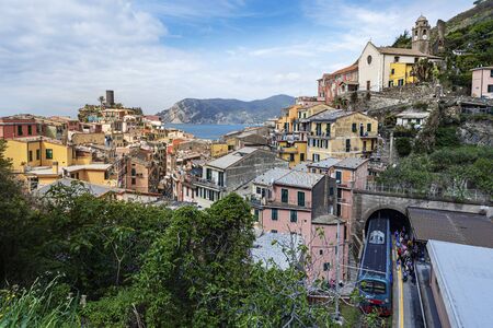 Vernazza, Italy ? ?? May 2, 2019 View at Vernazza village from the Railway sation with the train arrived and passengers tourists moving to the exit. Castello Doria is at left. Cinque Terre, Liguria, Italy.のeditorial素材