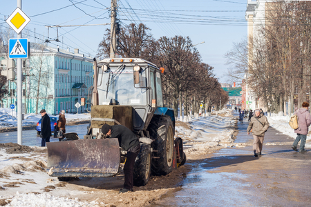 Tractor removes snow on the sidewalk path. Snowfall in Cheboksary, Chuvash Republic, Russia.のeditorial素材