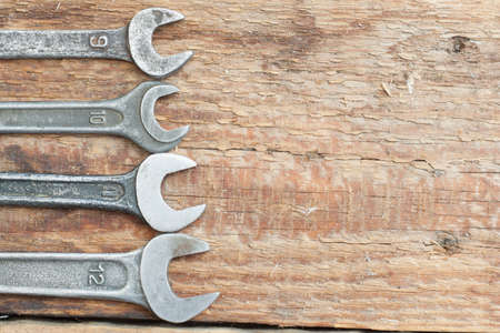 A collection of small wrenches on wooden background. The old shop.の写真素材