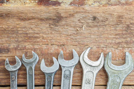 A collection of small wrenches on wooden background. The old shop.