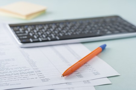 Workplace accountant. Documents, pen, keyboard, paper for notes.の写真素材