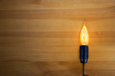 The light from an incandescent lamp on vintage wooden background.の写真素材