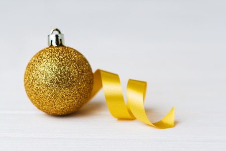 Golden christmas ball on wooden white background.の写真素材