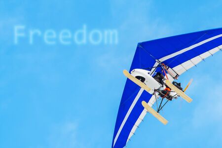 The motorized hang glider in the blue sky. Freedom, success, vacation, business conceptsの写真素材