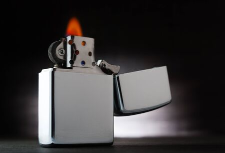 Old metal lighter on a wooden backgroundの写真素材