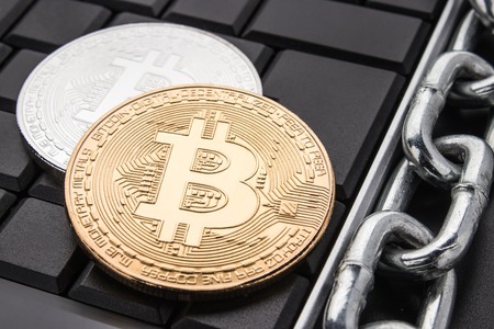 Coins bitcoin on dark keyboard. Metal chain. Concept of blockchain technology.