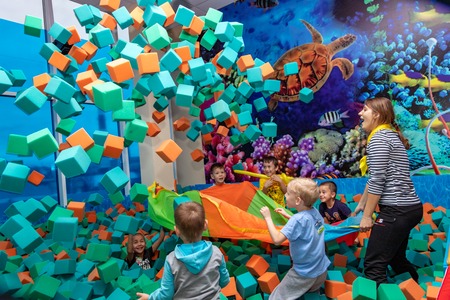 Children play with the animator in the entertainment center. Children play in the pool with soft cubes. Cheboksary, Russia, 10/20/2018のeditorial素材