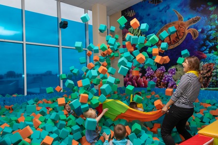 Children play with the animator in the entertainment center. Children play in the pool with soft cubes. Cheboksary, Russia, 10/20/2018のeditorial素材