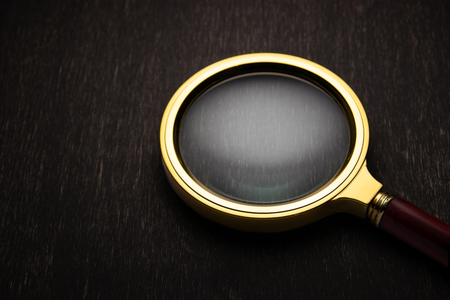 Golden magnifier on a dark background..の写真素材