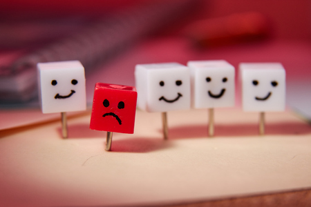 The concept of sadness, loneliness, disappointment. Shaped characters from office pins. Red background.の写真素材