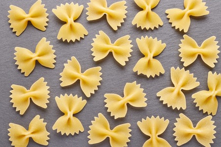 Food ingredients for cooking pasta on the background of black slate. Background of uncooked pasta.の写真素材